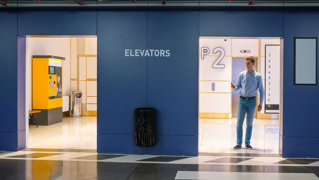 Man Standing Near Elevators At Parking Garage