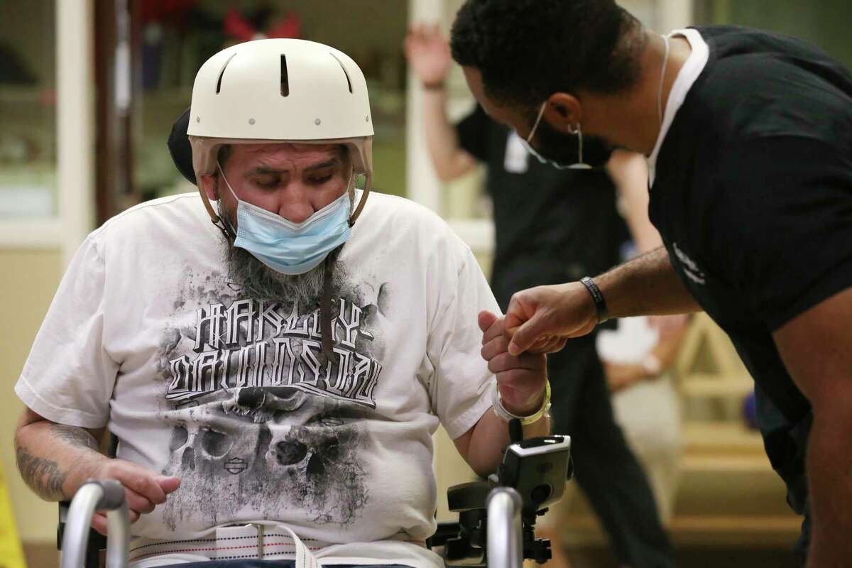 Joe Angel Garcia, 43, gets a fist bump from staff after completing a task during rehab at Warm Springs Rehabilitation Hospital on July 28, 2022. Last year, Garcia was riding his Harley Davidson when an SUV driven by an intoxicated Lorenzo Caltzontzi-Jimnez veered into his pathway. Garcia suffered severe brain, spinal and other injuries, including a collapsed lung and a lacerated aorta. In July 2022, the drunken driver, Caltzontzi-Jimenez, pleaded guilty to intoxication assault and was sentenced to five years in prison. Almost a year after the crash, Garcia was able to get the state-funded rehab at the hospital for three months.